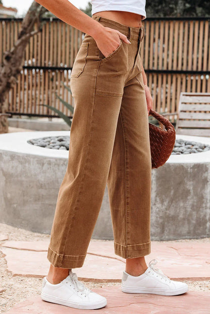 Woman wearing high-waisted tan wide-leg pants with pockets and white sneakers outdoors
