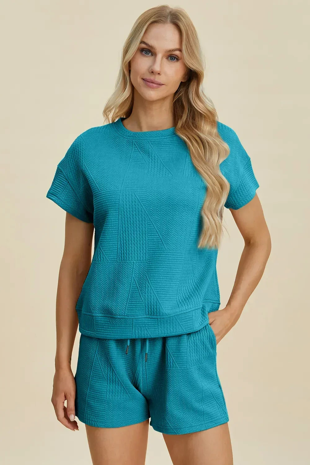 Woman wearing textured teal short-sleeve top and matching shorts set