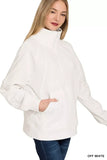 Woman wearing an off-white half-zip pullover sweater with front pocket and high collar