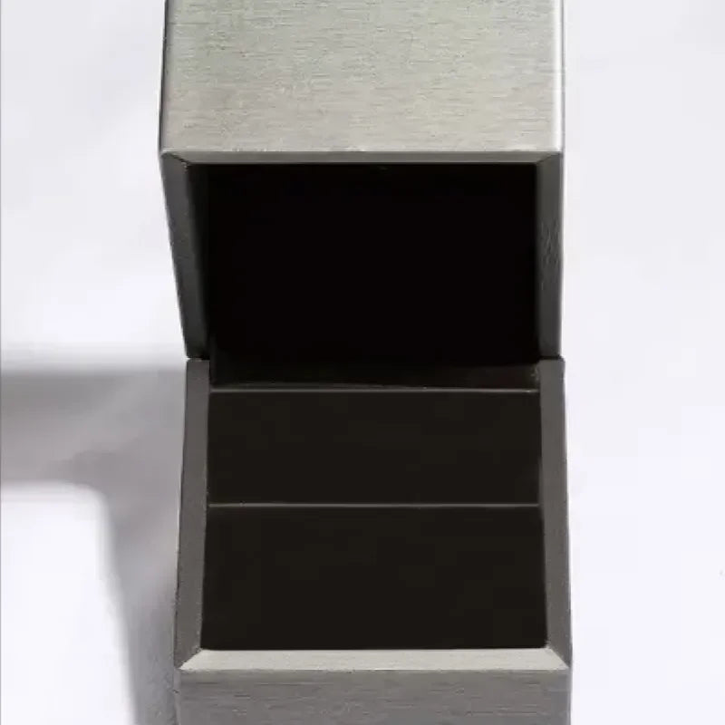 Empty metallic rectangular jewelry box with hinged lid on a white background