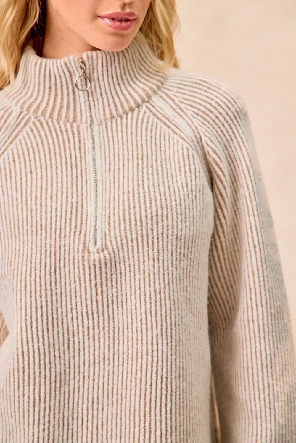 Beige and white striped knit pullover with half-zip mock neck and relaxed fit.