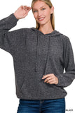 Woman wearing a charcoal knit hoodie with relaxed fit and front pocket, paired with jeans.