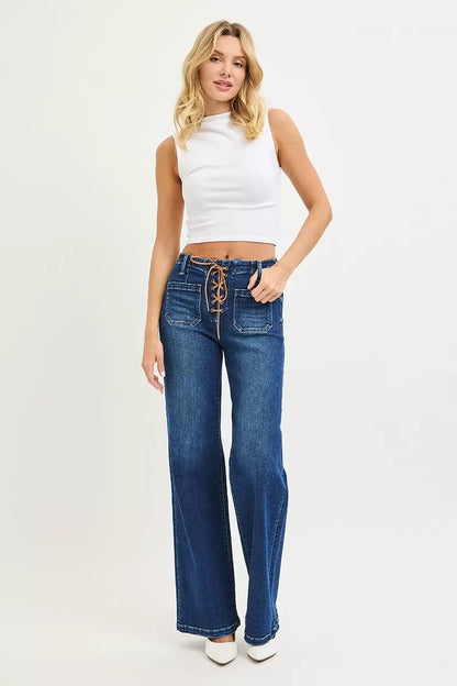 Woman wearing high-waisted wide-leg blue jeans with lace-up front and sleeveless white top