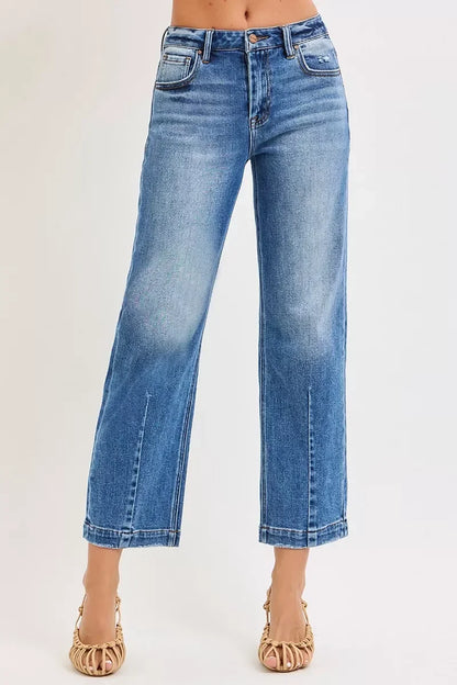 Woman wearing high-waisted wide leg blue jeans with subtle fading, paired with woven sandals