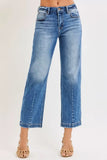 Woman wearing high-waisted wide leg blue jeans with subtle fading, paired with woven sandals