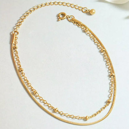 Gold layered chain bracelet with adjustable clasp on light background