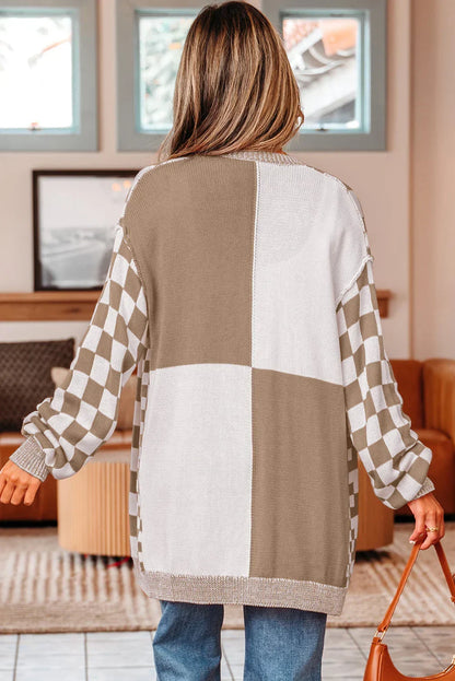 Woman in neutral checkered and colorblock cardigan with relaxed fit, holding a tan purse indoors