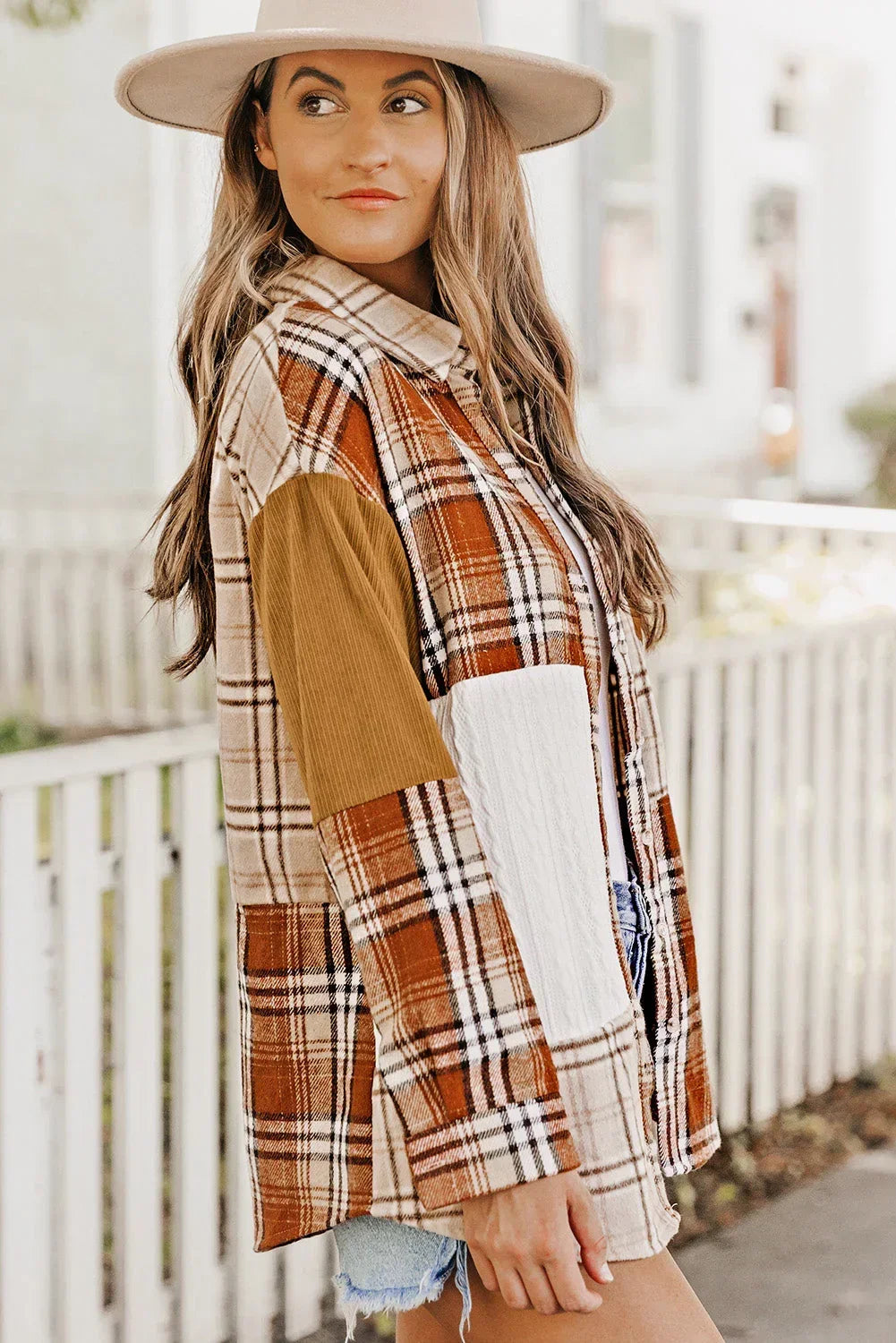 Woman in beige hat wearing a patchwork plaid shacket with corduroy sleeves outdoors