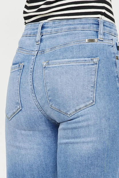 Back view of light wash high-waisted women's jeans with classic pockets and striped top