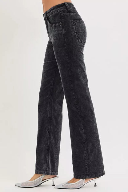 Woman wearing high-waisted black wide-leg jeans and silver pointed-toe heels