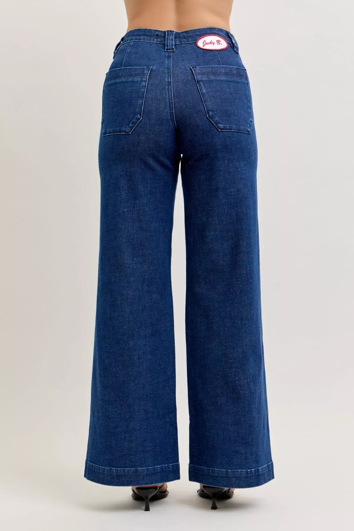 Back view of wide-leg high-waisted blue jeans with patch pockets and black heels