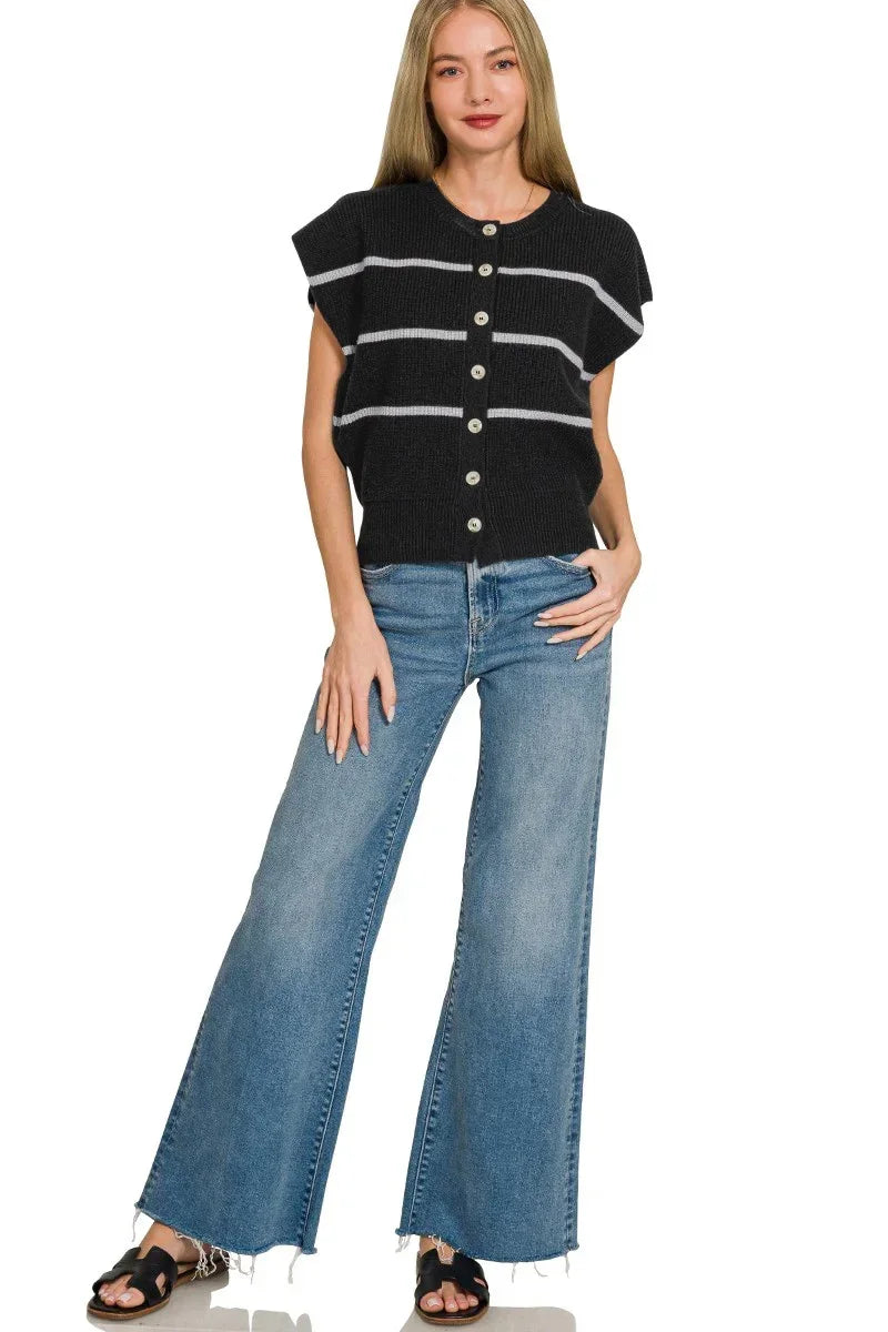 Woman wearing a black striped button-up knit top with wide-leg jeans and black sandals.