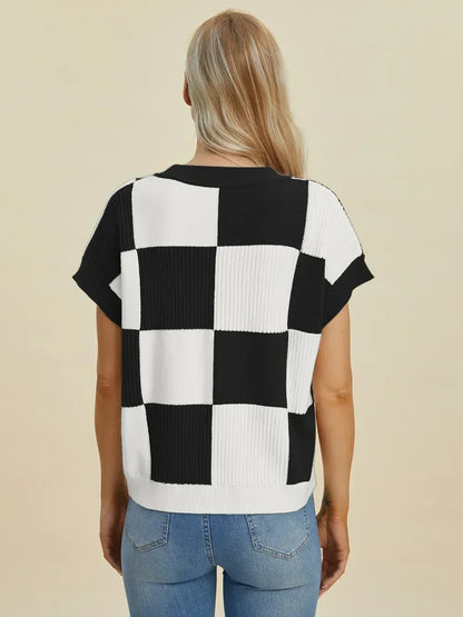 Woman wearing black and white checkered knit top with short sleeves and light blue jeans