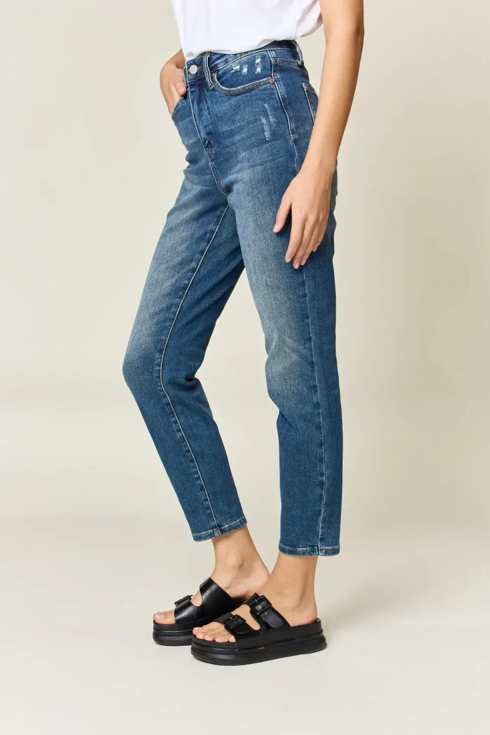 Woman in high-waisted blue straight leg jeans and black platform sandals