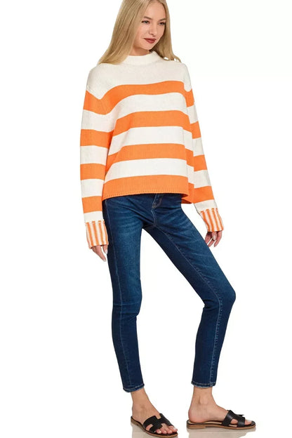 Woman wearing an orange and white striped knit sweater with blue skinny jeans and black sandals