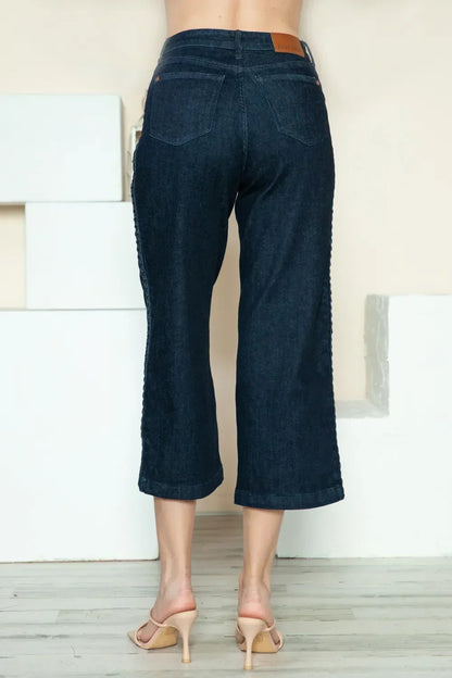 Back view of woman wearing dark wash wide-leg cropped jeans and nude heels