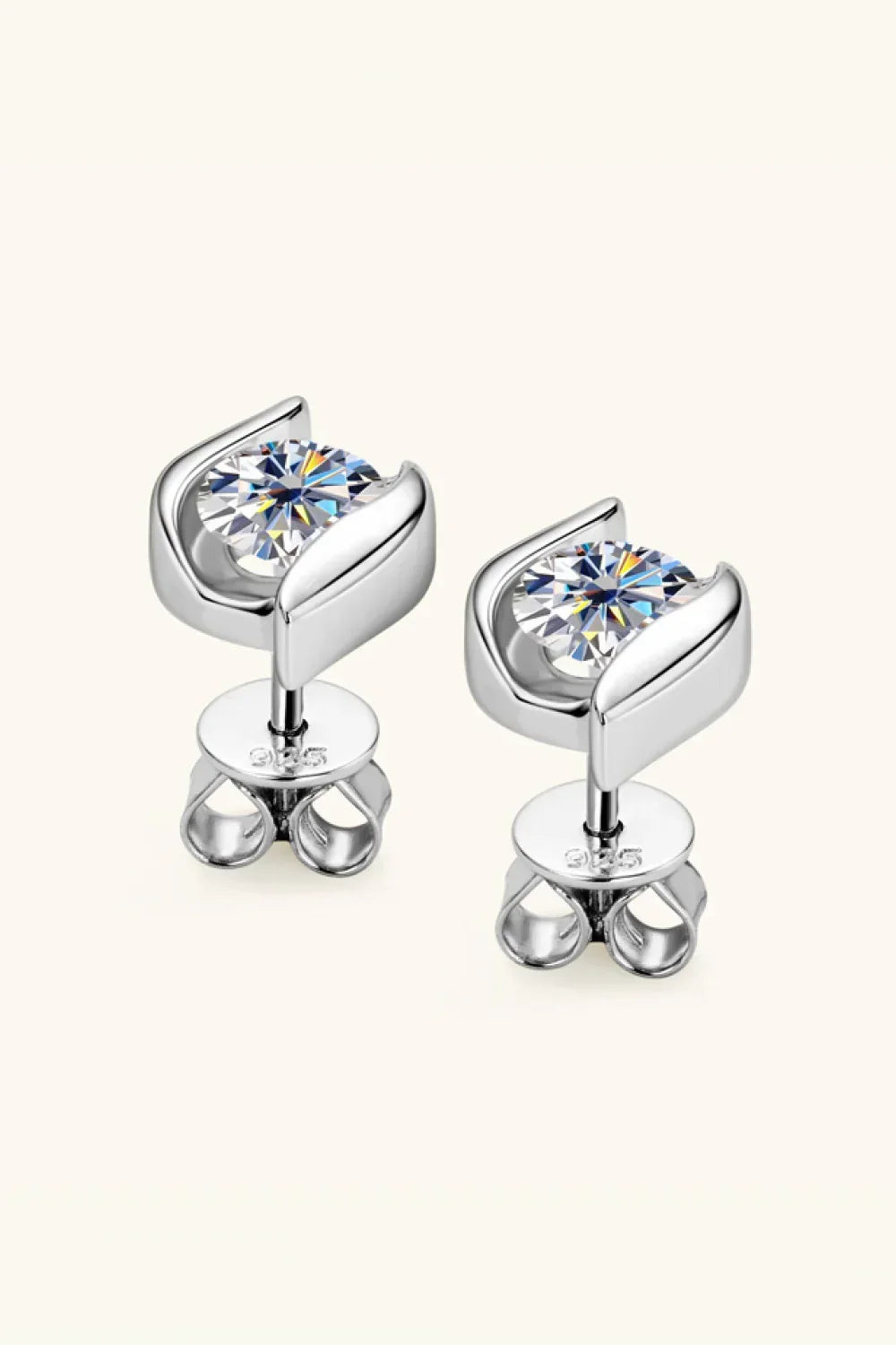 Silver stud earrings with round clear gemstones on a neutral background