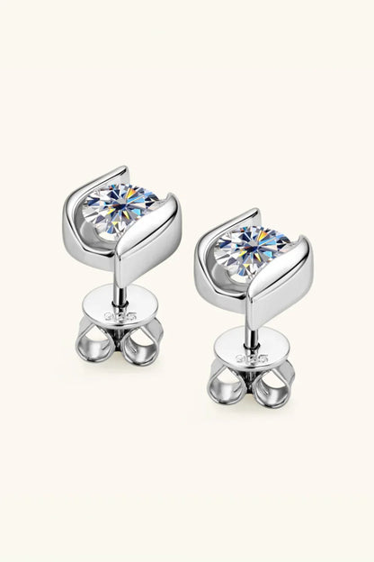 Silver stud earrings with round clear gemstones on a neutral background