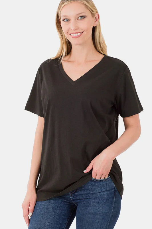 Woman in black V-neck short sleeve relaxed fit t-shirt and blue jeans against white background