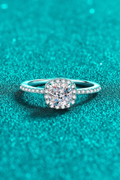 Cushion halo diamond ring with pavé band on sparkling turquoise background