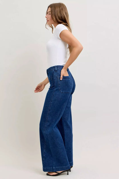 Woman wearing high-waisted wide-leg blue jeans and a fitted white short-sleeve top