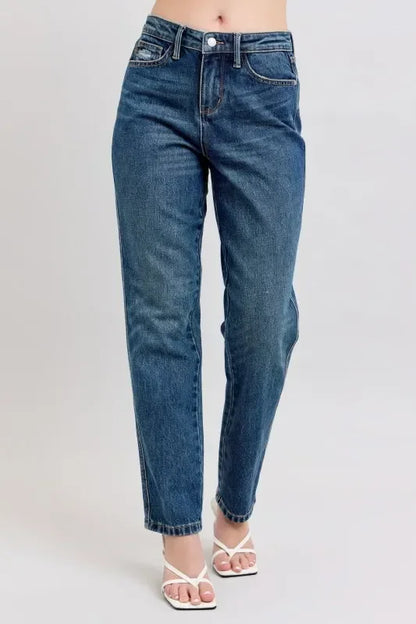 Woman wearing high-waisted relaxed fit blue jeans and white strappy sandals