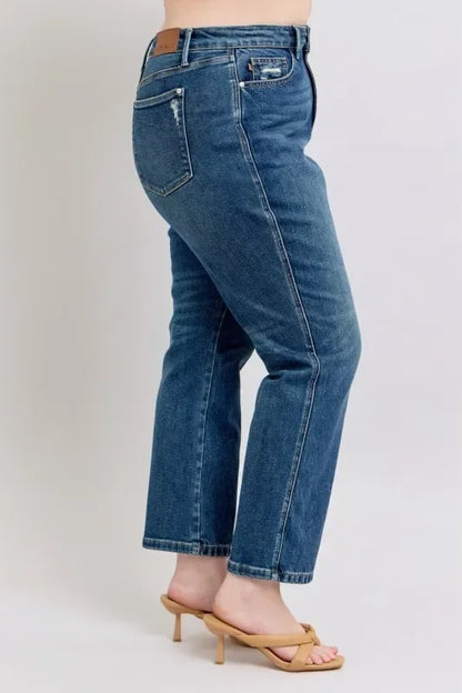 Woman wearing straight-leg blue jeans and tan heeled sandals, side view