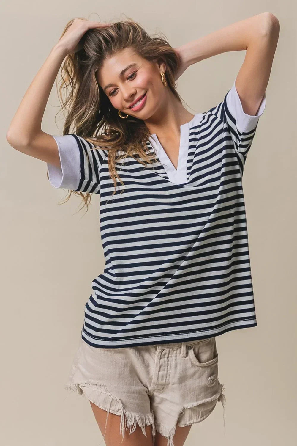 Woman wearing navy and white BiBi Contrast Striped Notched Knit Top with white trim and beige frayed shorts
