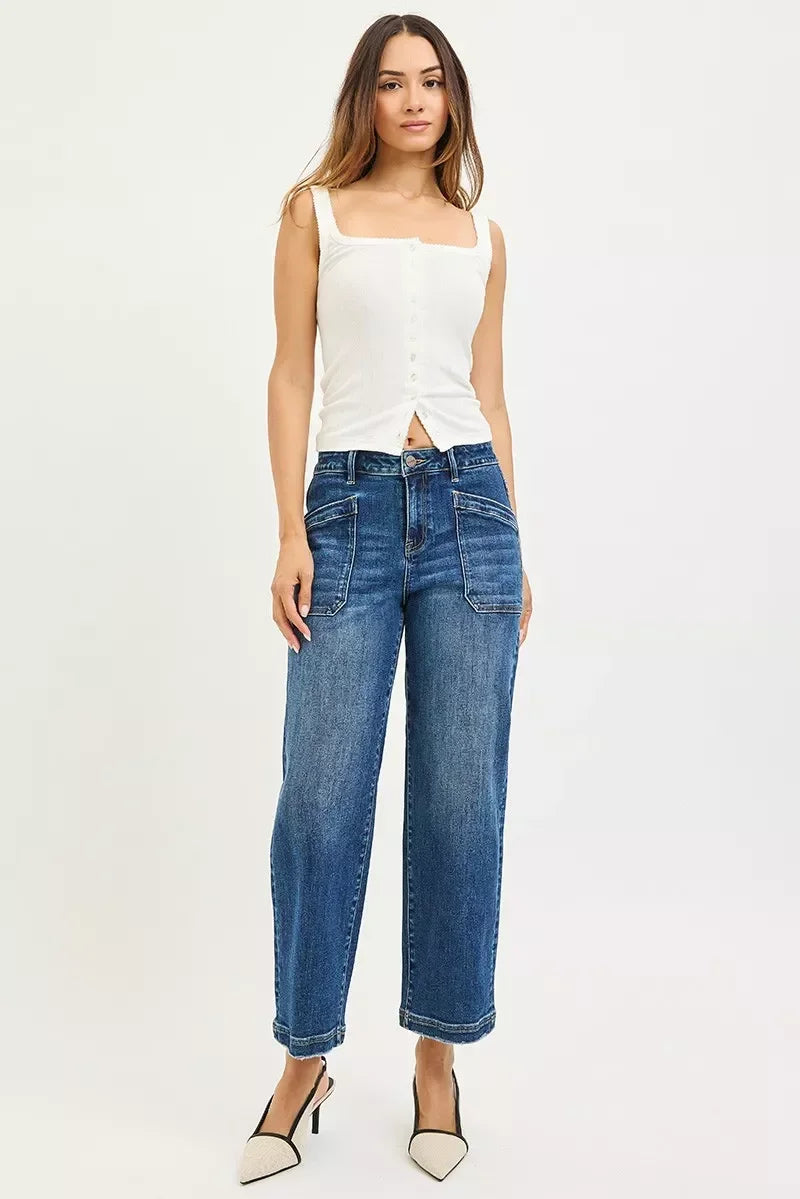 Woman wearing a sleeveless white button-down top with relaxed wide-leg blue jeans