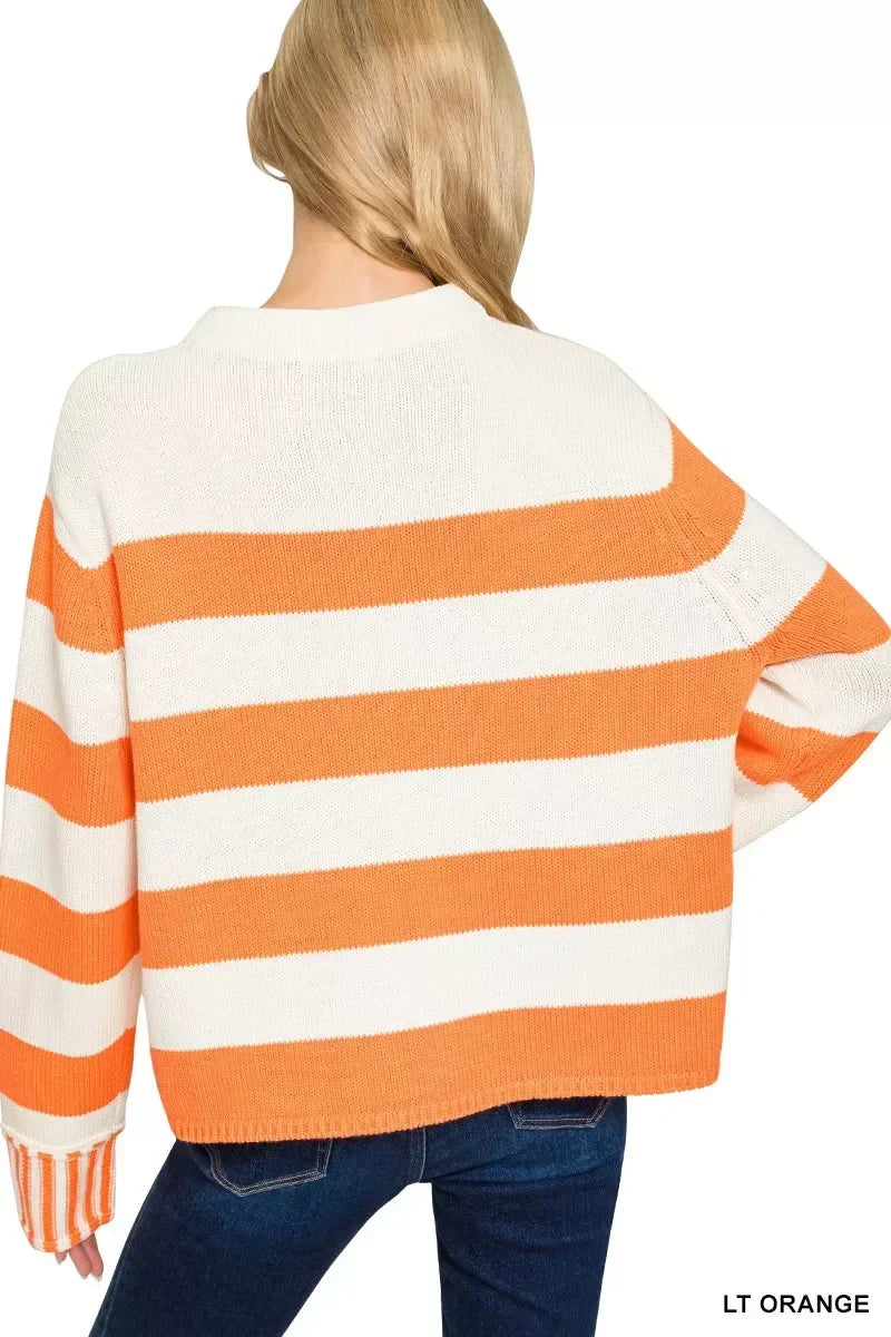 Back view of woman wearing orange and white striped knit sweater with relaxed fit