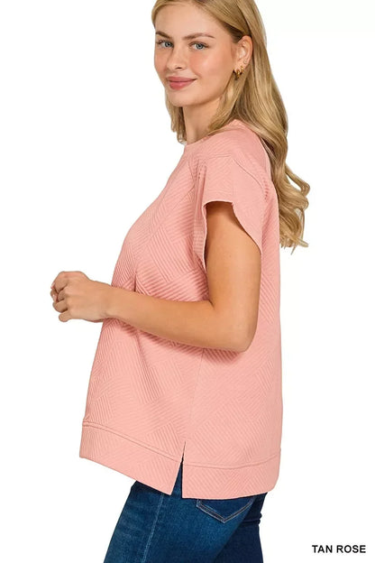 Woman in relaxed fit rose tan textured short sleeve top and blue jeans