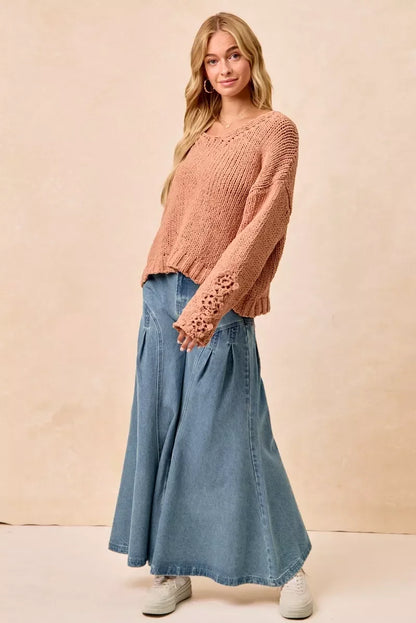 Woman in relaxed knit sweater and wide-leg denim maxi skirt, casual neutral background