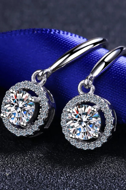 Elegant silver drop earrings with round cut clear crystals and pavé accents on dark background
