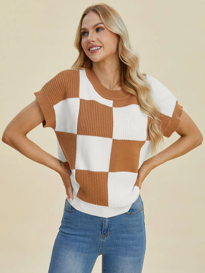 Woman wearing a brown and white checkered short sleeve knit sweater with blue jeans