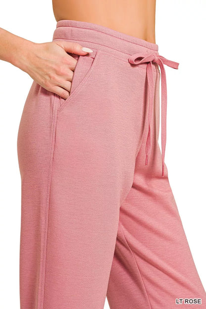 Close-up of woman wearing light rose pink drawstring lounge pants with pockets