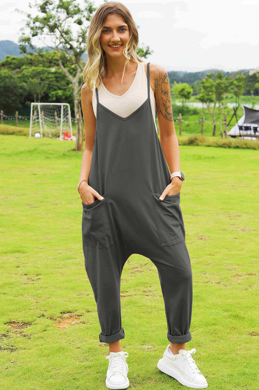 Woman outdoors wearing relaxed charcoal jumpsuit with side pockets and white sneakers