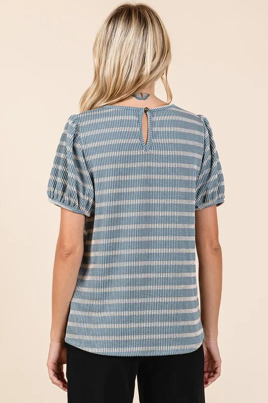 Back view of a woman wearing a blue and white striped short sleeve blouse with keyhole detail.