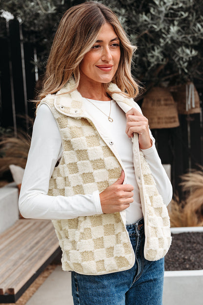 Woman wearing a checkered sherpa vest over a white long sleeve top and blue jeans outdoors