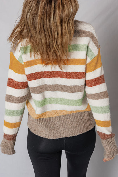 Back view of woman wearing a cozy striped knit sweater with earth tone colors and black leggings