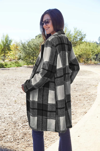 Woman outdoors wearing a black and white plaid coat and sunglasses