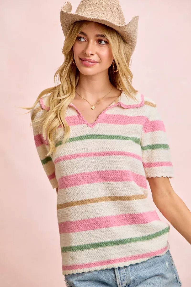 Woman wearing a pink, green, and beige striped knit top with short sleeves and a beige cowboy hat.