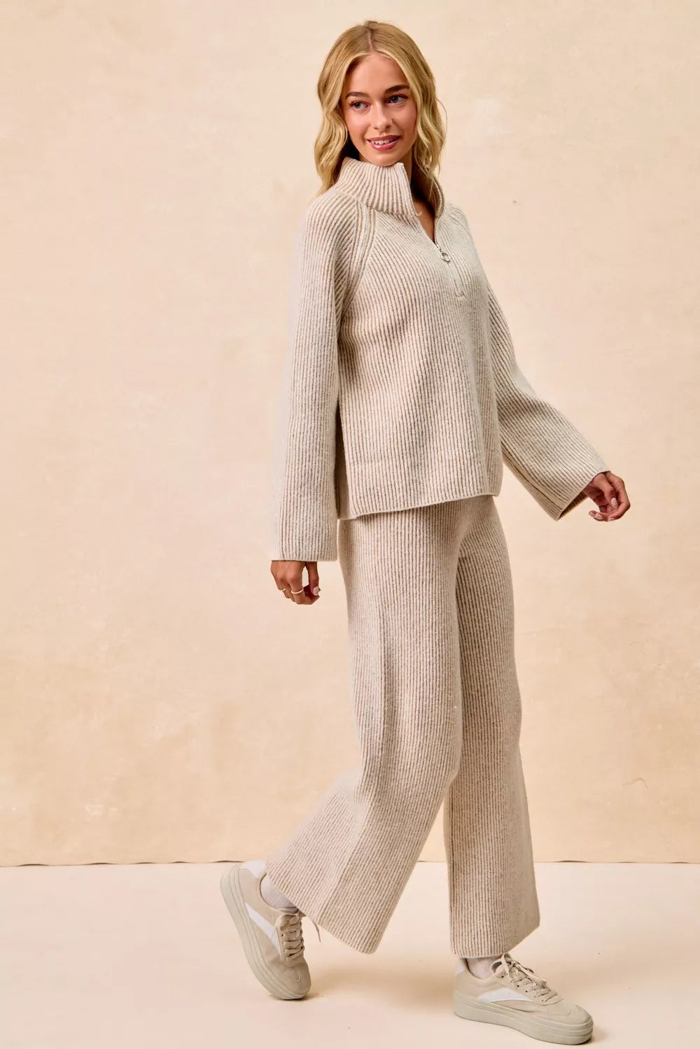 Woman wearing a beige ribbed knit pullover and matching wide-leg pants set
