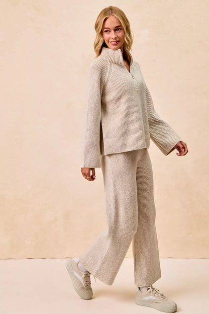 Woman wearing a beige ribbed knit pullover and matching wide-leg pants set