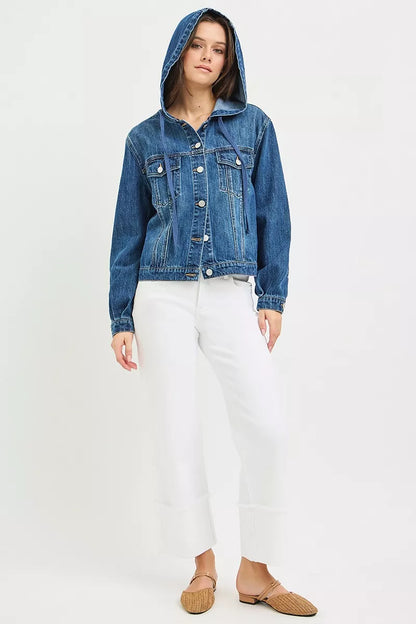 woman wearing a button-up Denim Jacket with Hoodie, white tank top and white jeans, and tan slip-on flats in front of a white background