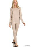 Woman wearing a beige long-sleeve top and leggings on a white background