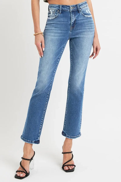 Woman wearing high-waisted, straight-leg blue jeans with distressed details