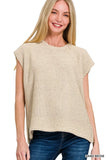 Woman wearing a sleeveless sand beige knit top with relaxed silhouette and crew neckline.