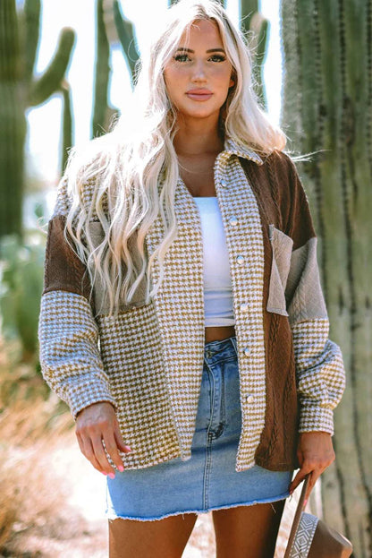 Woman wearing a colorblock houndstooth jacket, white crop top, and denim mini skirt outdoors