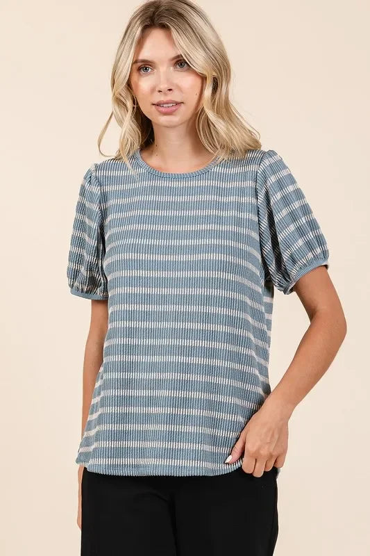 Woman wearing a blue striped short-sleeve blouse with relaxed fit and puffed sleeves