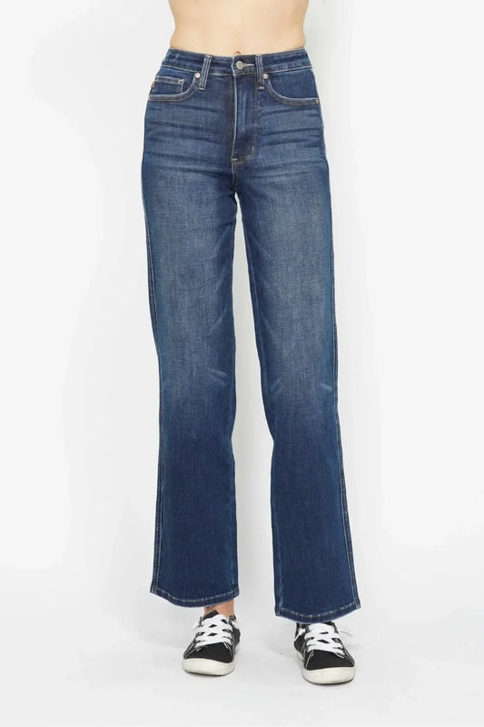 High-rise wide leg jeans with classic blue wash, styled with black sneakers.